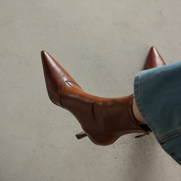 Brown leather pointed toe cowhide stiletto ankle boot with a sharp pointed toe low heel and zipper.