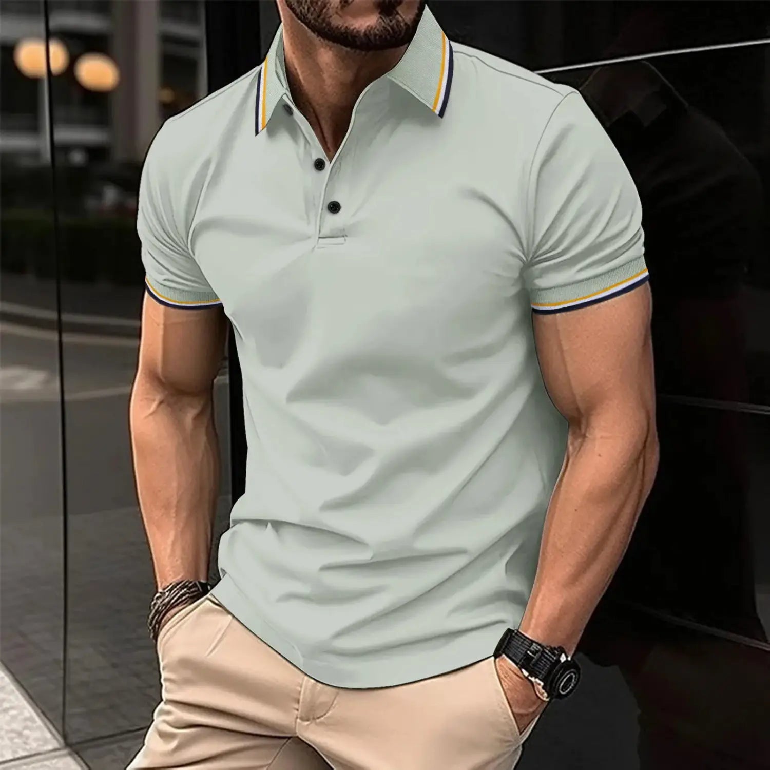 Kontrastiertes Herren-Poloshirt in Hellgrün mit gelben und navyblauen Akzenten an Ärmel und Kragen, mit kurzen Ärmeln und klassischem Kragen-Design.