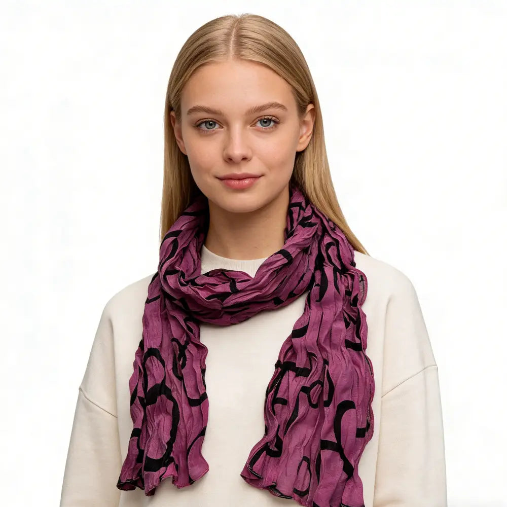 un foulard en polyester froncé fuchsia, drapé avec élégance autour du cou, présentant un tissu pourpre souple et fluide, avec un motif abstrait noir audacieux