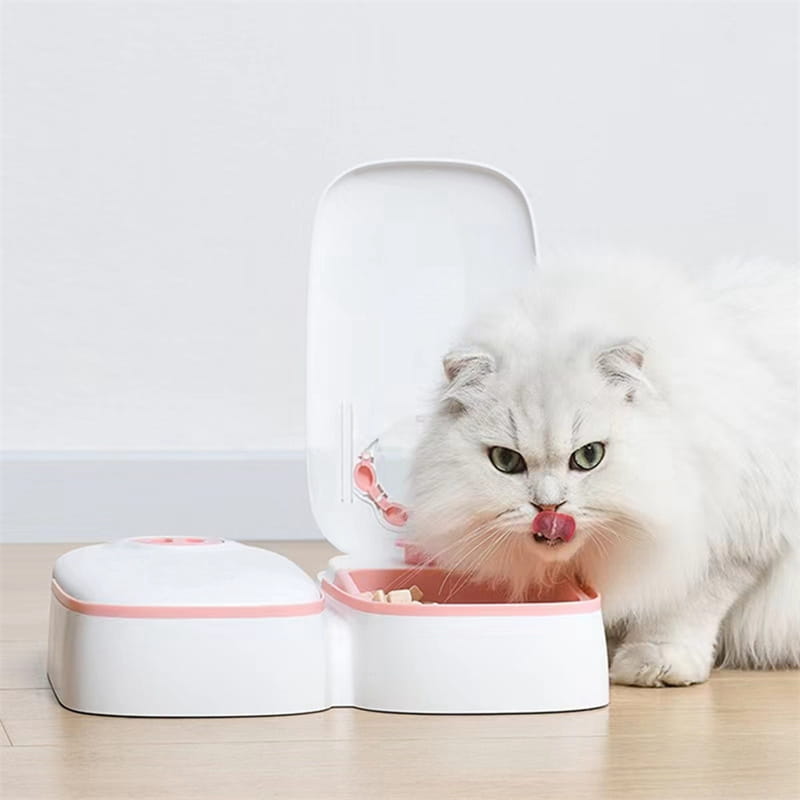 White and pink dual-compartment automatic pet feeder with hinged lid for gravity water and food dispensing.