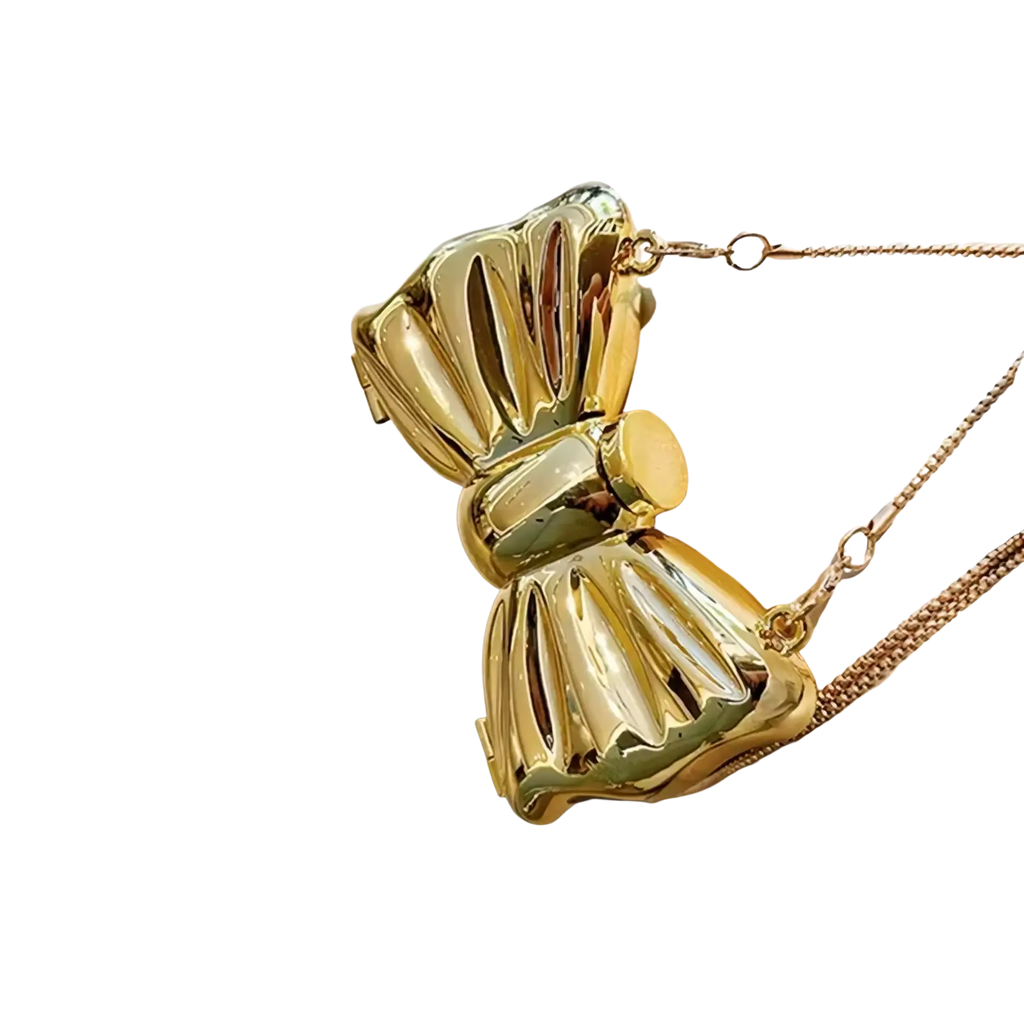 A shiny gold metallic acrylic bow crossbody bag clutch with a chain strap suitable for formal occasions