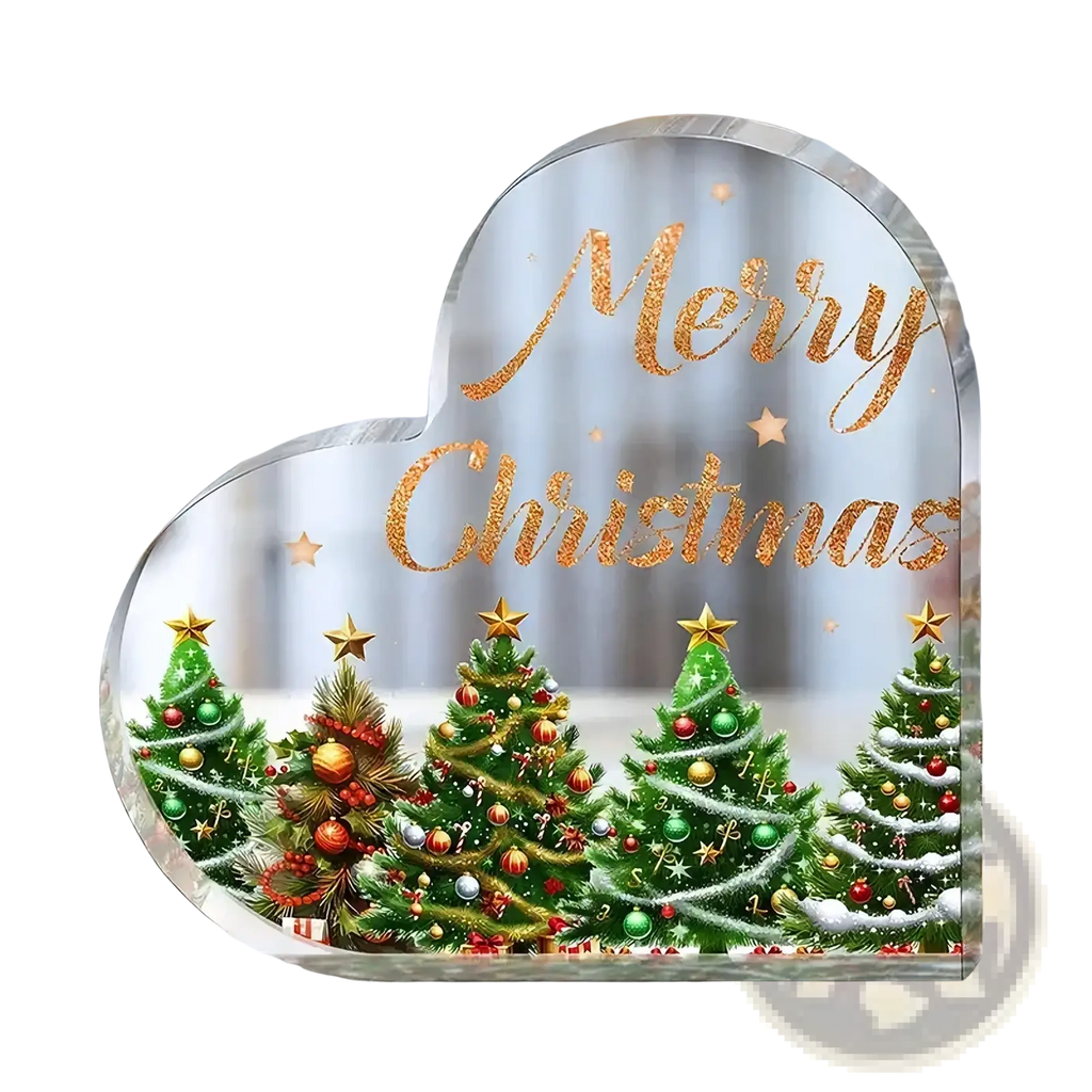 Clear acrylic christmas heart ornament with glittery gold merry christmas text and decorated green pine trees on desktop stand