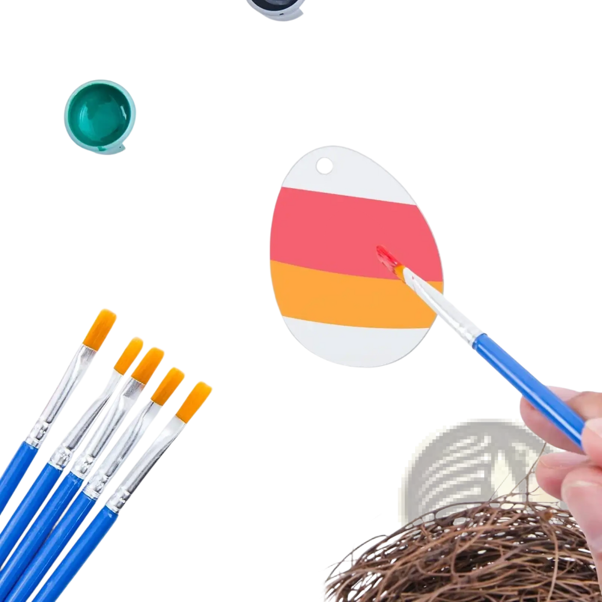 A hand-painted acrylic Easter egg ornament with red and orange stripes on a white base being painted with a brush