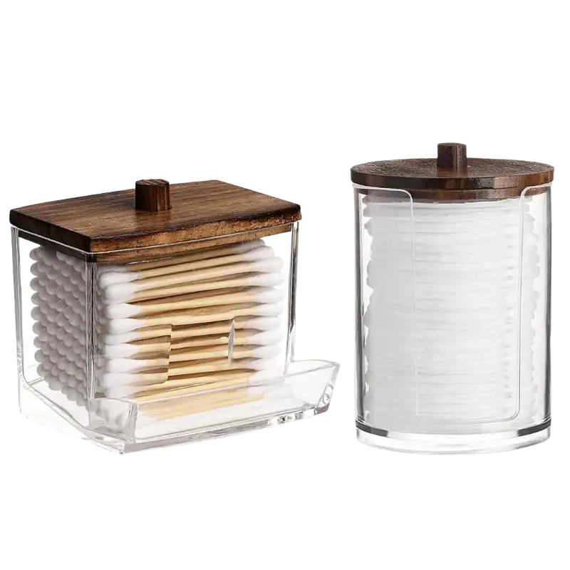 Clear acrylic q-tip and cotton ball storage jars with dark wood lids for organized bathroom use