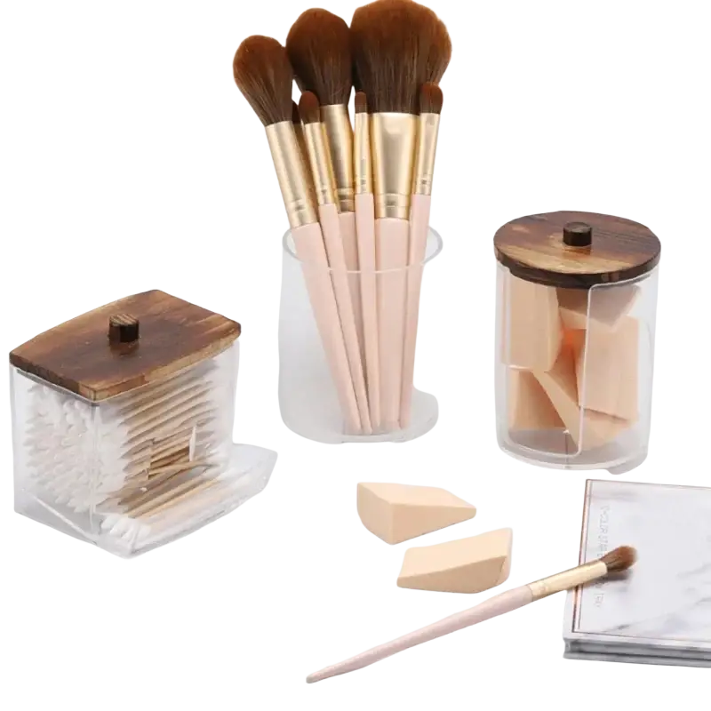 Set of makeup brushes with soft brown bristles and pale pink handles with gold ferrules for acrylic q-tip storage jar set