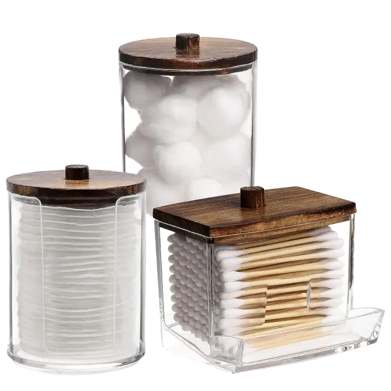 Set of three clear acrylic q-tip and cotton ball storage jars with dark wood lids for bathroom organization