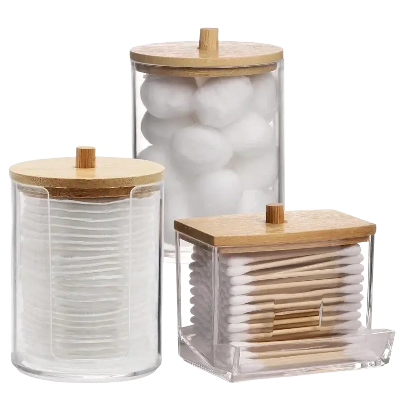 Set of three clear acrylic q-tip and cotton ball storage jars with bamboo lids holding assorted cotton products