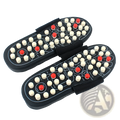 Black acupressure massage slippers for men and women with white and red acupressure points on the soles