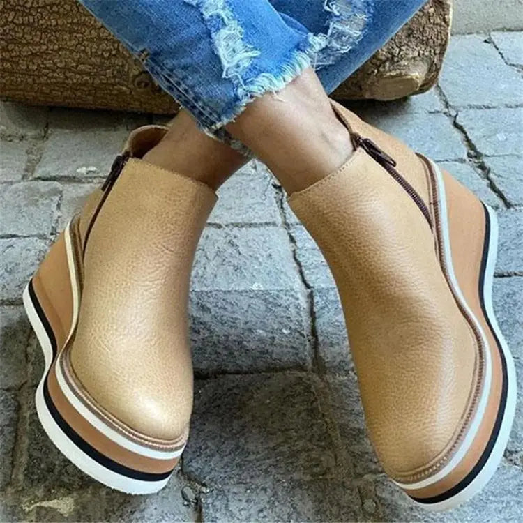 Botines de mujer de cuero color cuero tostado con suela gruesa en plataforma y cuña, con detalles a rayas.