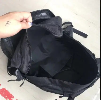 Black nylon tactical camouflage mountaineering backpack with multiple zippered compartments and adjustable shoulder straps for hiking shown from the back side.