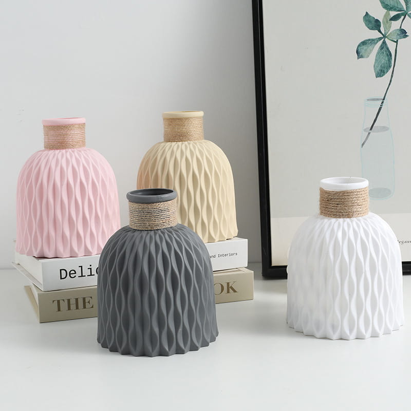 Set of four pastel-colored ceramic vases with wavy textured ribbed bodies and natural twine-wrapped necks in a decorative ceramic vase set 4 pack.