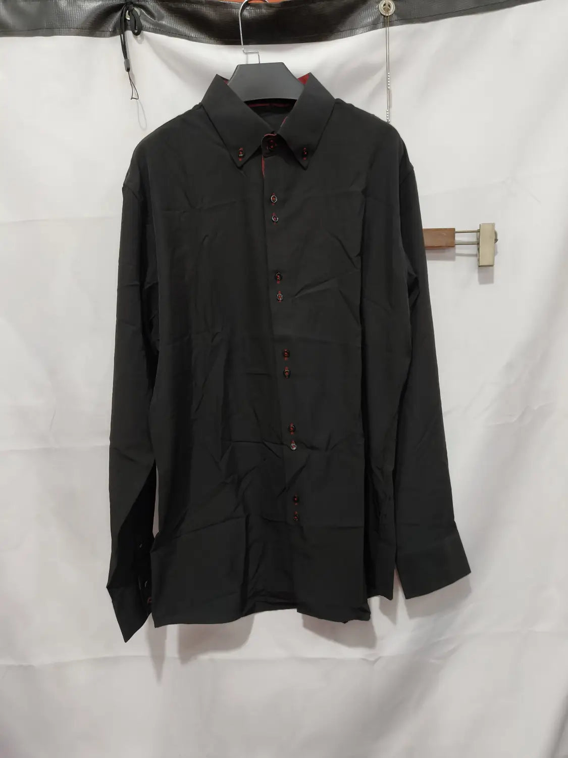 Chemise habillée stretch à empiècements contrastés noire avec détails de coutures rouges discrets.