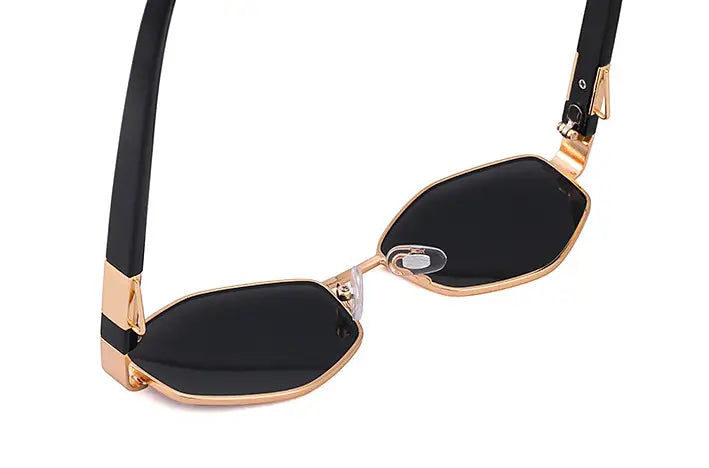 Black octagonal women’s sunglasses with gradient lenses, gold-tone metal frames, black temple arms, and chain accent.