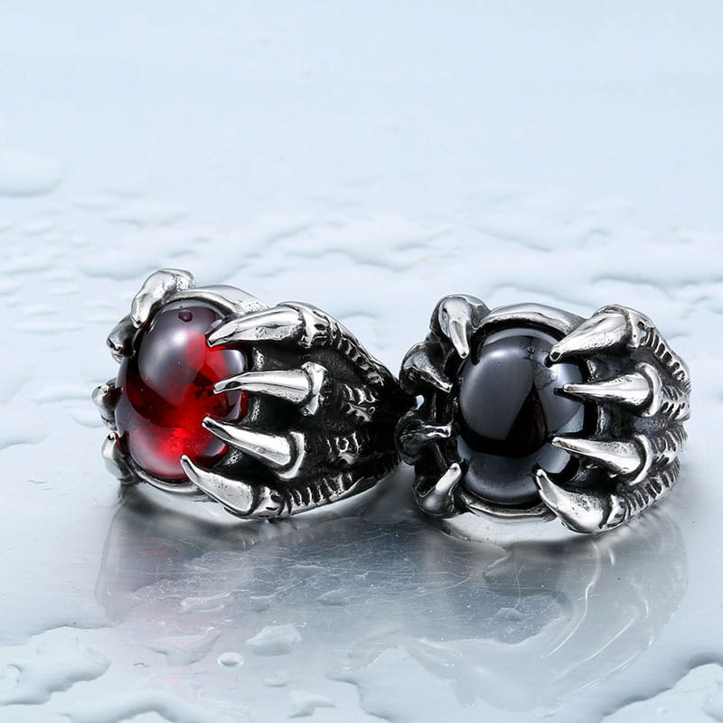two vintage titanium steel claw rings featuring intricately designed silver metallic claws each set with a prominent zircon gemstone in red and black colors