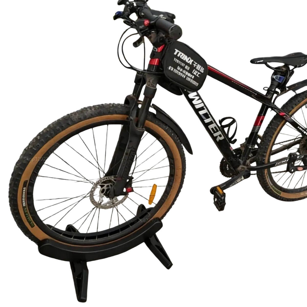 Adjustable bike parking stand holding a black mountain bike with red accents tan tires front suspension and disc brakes