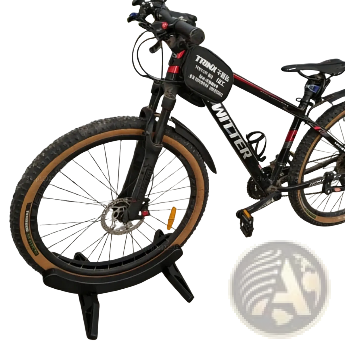 Adjustable bike parking stand holding a black mountain bike with red accents tan tires front suspension and disc brakes