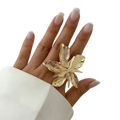Adjustable double layer flower ring in gold tone with intricate petal details worn on a finger