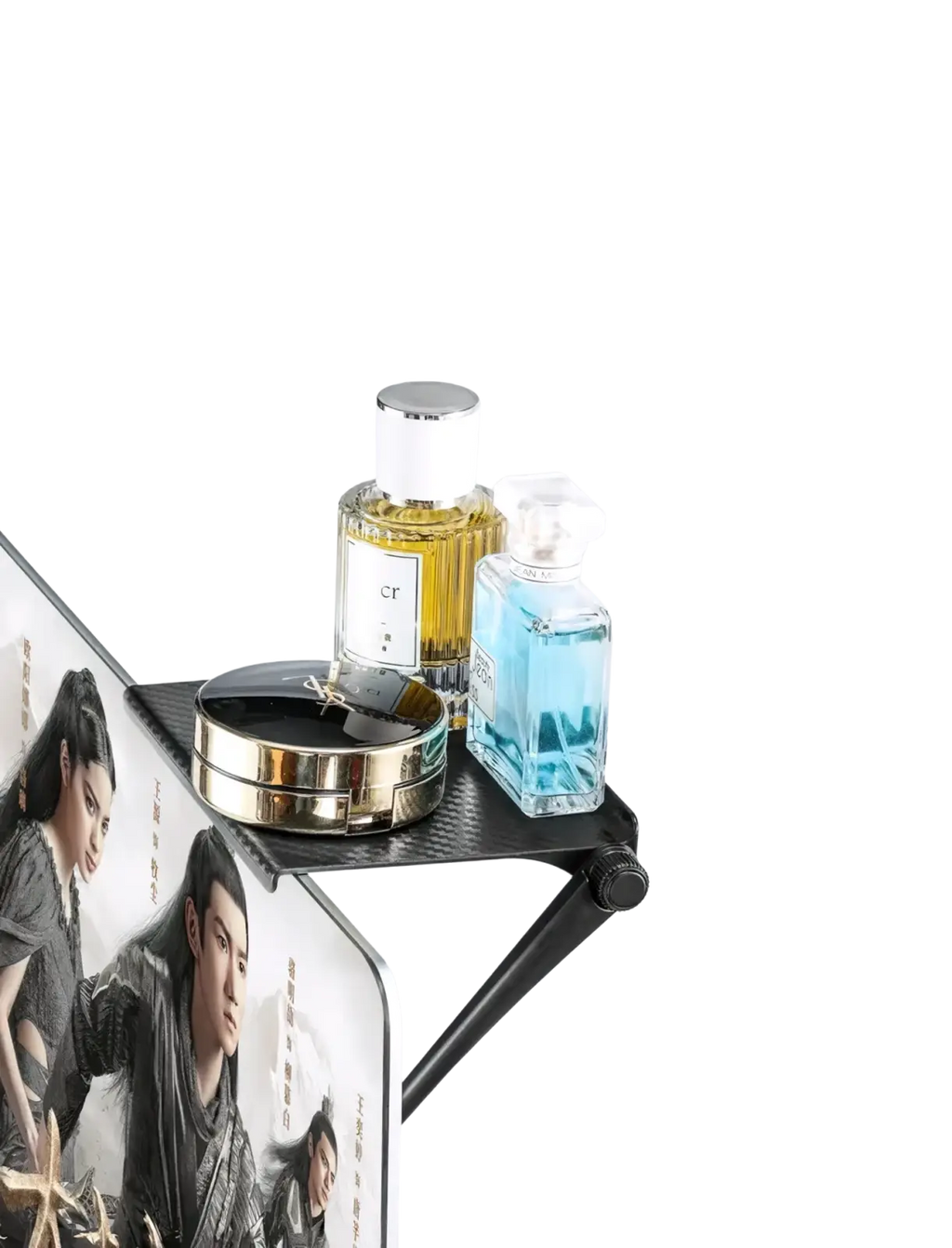 Black carbon fiber adjustable screen top storage shelf monitor stand holding two perfume bottles and a compact mirror