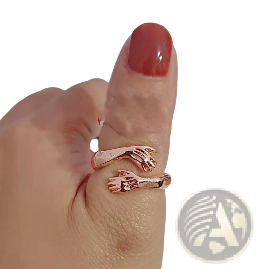 Adjustable rose gold ring with two interlocking hands design featuring a red gemstone in silver material