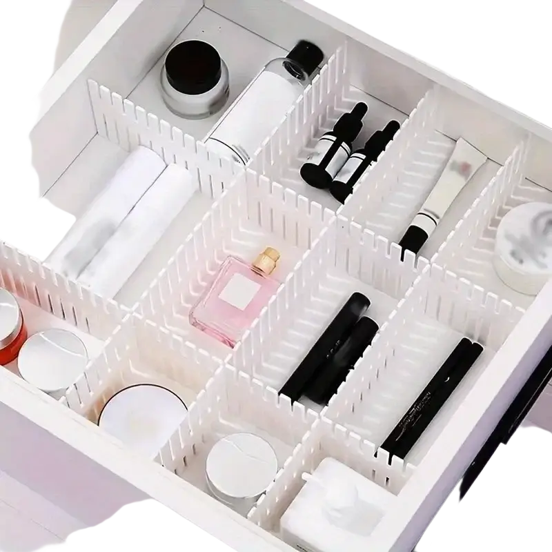 Adjustable white plastic drawer divider partition with segmented compartments holding various beauty products