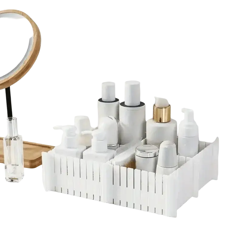 Adjustable white plastic drawer divider partition with vertical slats holding skincare bottles and containers