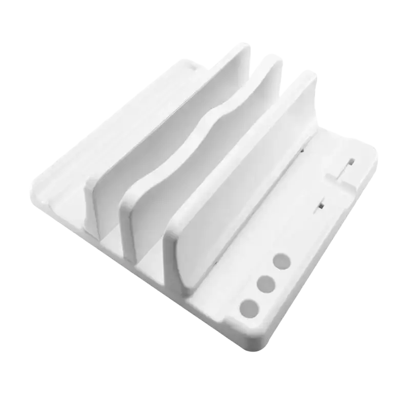 White plastic adjustable width laptop and tablet stand with three slots and circular indentations on the base for charging