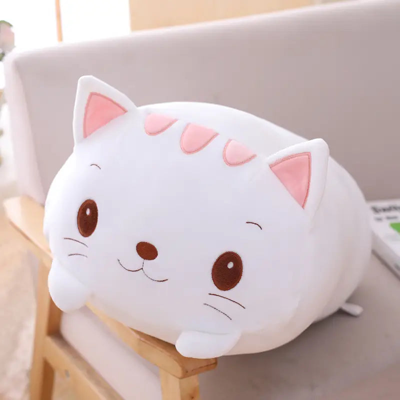 White plush cat pillow with pink inner ears, triangular markings, and brown embroidered eyes and nose soft cartoon doll for kids.