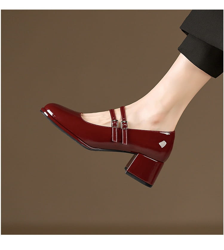 shiny burgundy patent leather mary jane shoe with block heel and double buckle straps in a front view