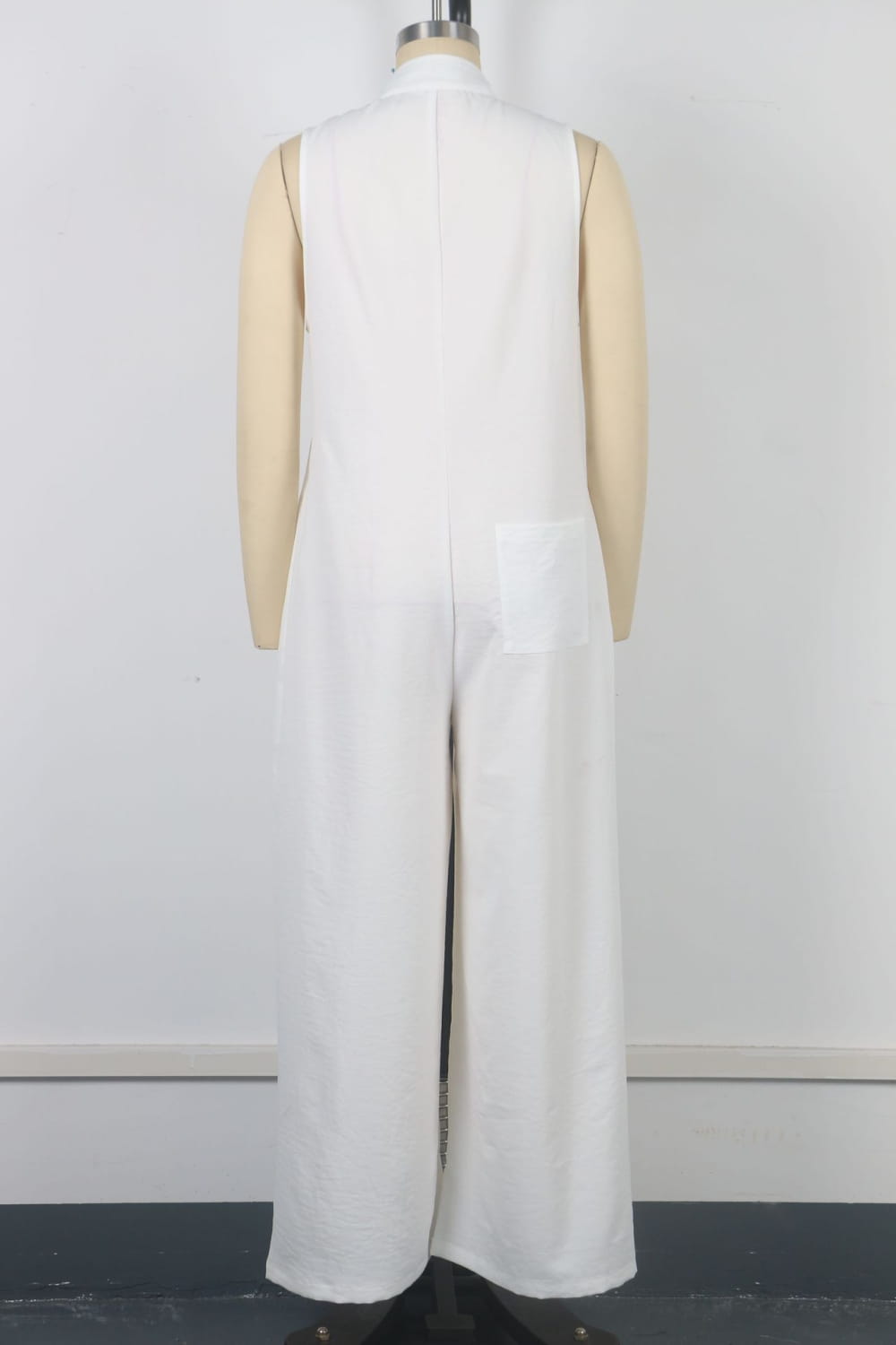Combinaison blanche sans manches à jambes larges avec un col haut, présentée sur un mannequin.