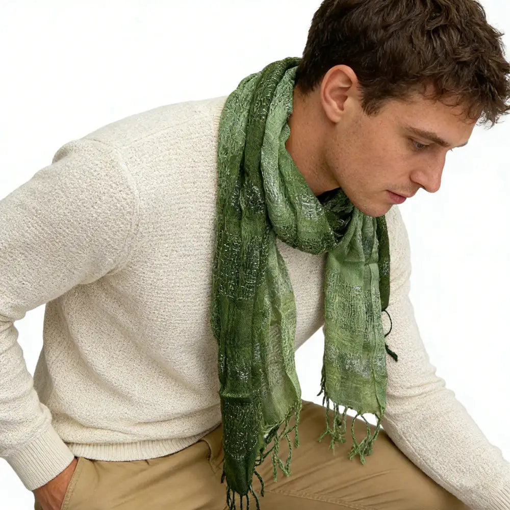 A soft olive green metallic shimmer scarf with a subtle textured pattern and fringed edges.