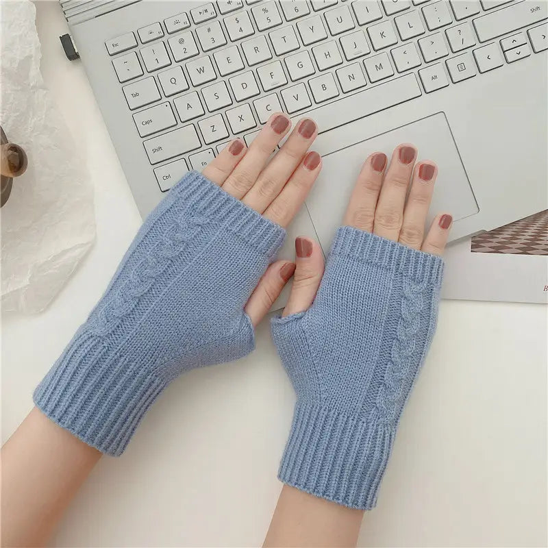 Light blue knitted fingerless gloves with a cable knit pattern and ribbed cuffs made of woolen material for unisex use.