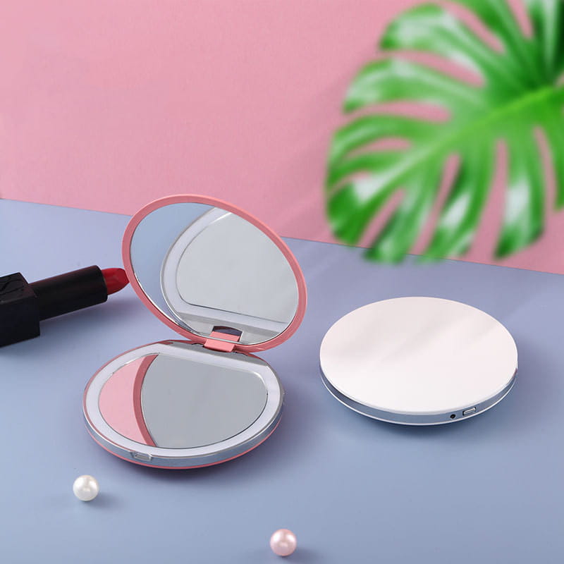 Espejo de maquillaje LED portátil compacto plegable USB en color rosa y plateado, con un diseño elegante y redondeado y una función de plegado compacta
