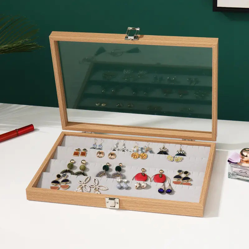 Rosewood jewelry display box with light wood finish rectangular shape glass lid and silver-toned metal clasps for earring storage.