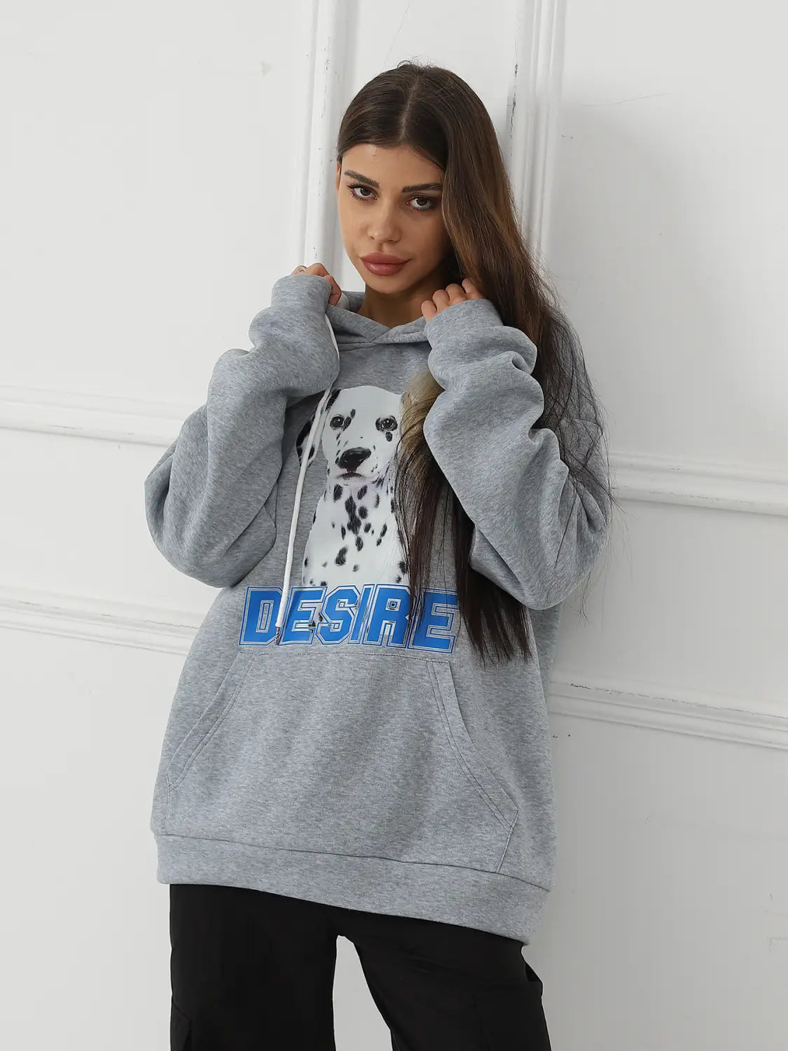 Women’s gray hoodie made of soft fabric featuring a white dalmatian dog graphic with black spots and the word desire in bold blue letters across the chest with a cat ear hood.