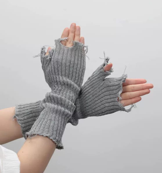 black tattered knit fingerless gloves unisex in gray knitted fabric with ribbed texture and intentionally frayed edges shown from the back side