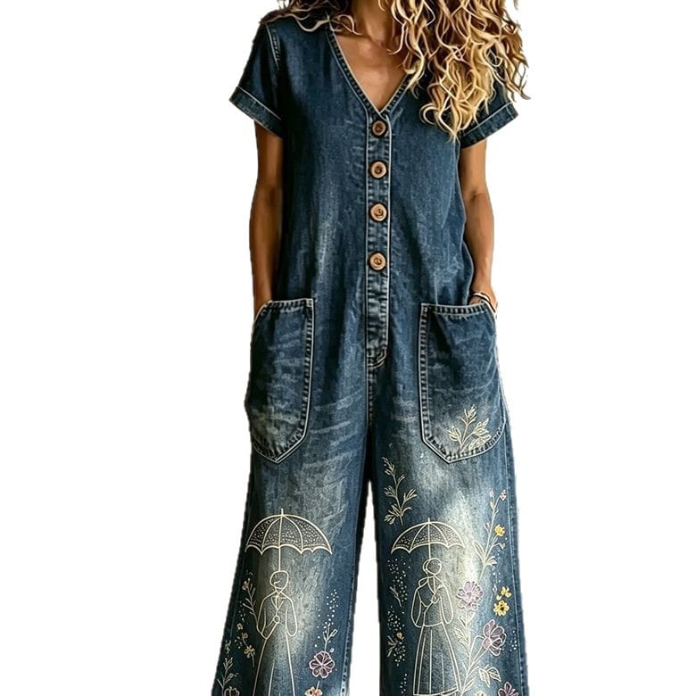 Denim-Jumpsuit mit kurzen Ärmeln, V-Ausschnitt und Knopfleiste; mit bestickten weißen, rosa und gelben floralen Mustern sowie Regenschirm-Designs an den weiten Beinen.