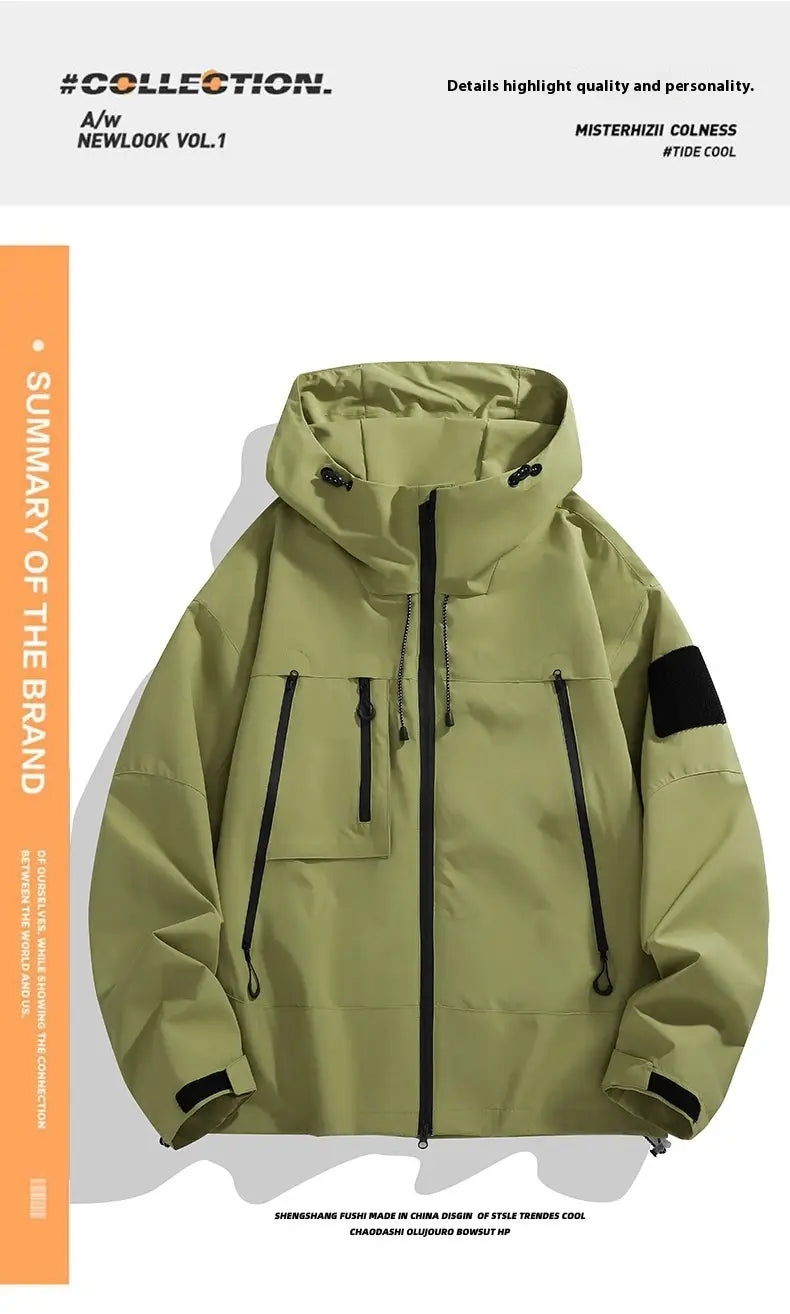 Olivgrüne taktische Kapuzen-Shelljacke mit schwarzen Reißverschluss-Akzenten und einem schwarzen Ärmelpatch, von der Rückseite aus dargestellt.