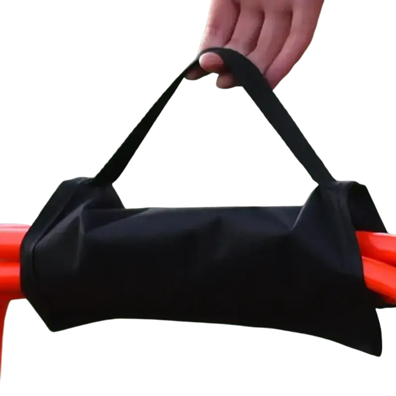 Black fabric carrying bag with sturdy handle designed to hold and protect orange resistance bands for training set black agility ladder and hurdle training set