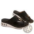 Black perforated leather air cushion thong sandals with white wedge sole and gold-tone metal buckle