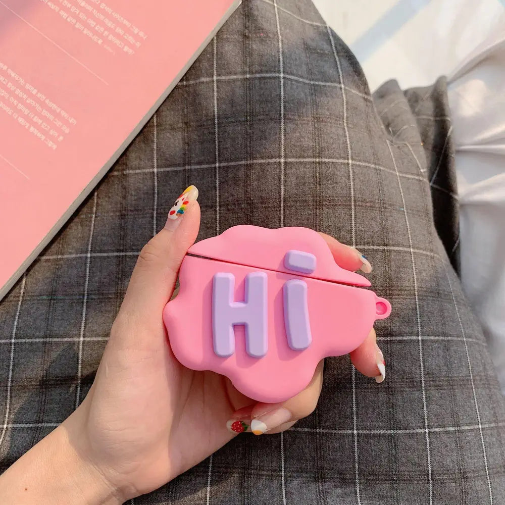 Pink silicone airpods 2 case with purple hi lettering and a small loop on the side in 3d hi bye speech bubble design