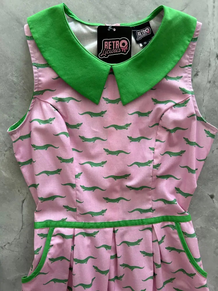 Pink retro cotton dress with green peter pan collar and alligator print featuring sleeveless design and pockets