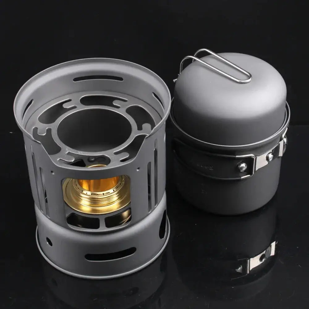 Gray aluminum camping stove with golden burner and pot from 7-piece portable cookware set ideal for outdoor use