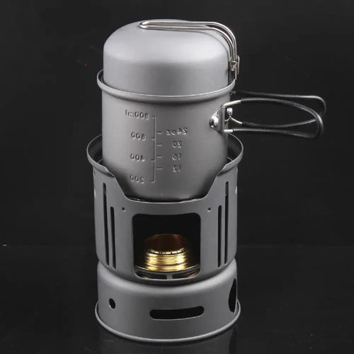 Gray aluminum portable camping stove with matching pot featuring measurement markings and wire handle for outdoor use