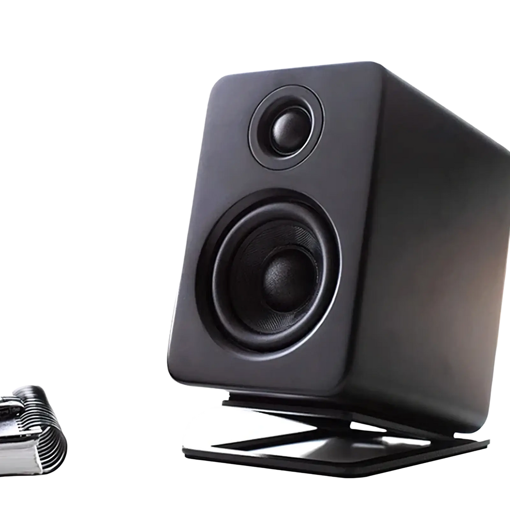 Black rectangular studio monitor speaker with matte finish and two circular drivers on aluminum desktop speaker stands with 16° tilt