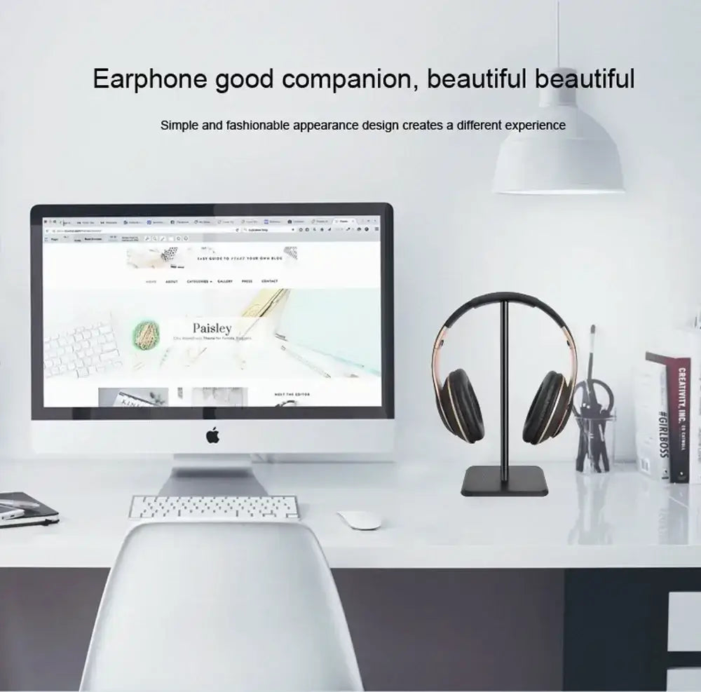 Black and gold over-ear headphones displayed on an aluminum headphone stand with soft silicone headset holder top