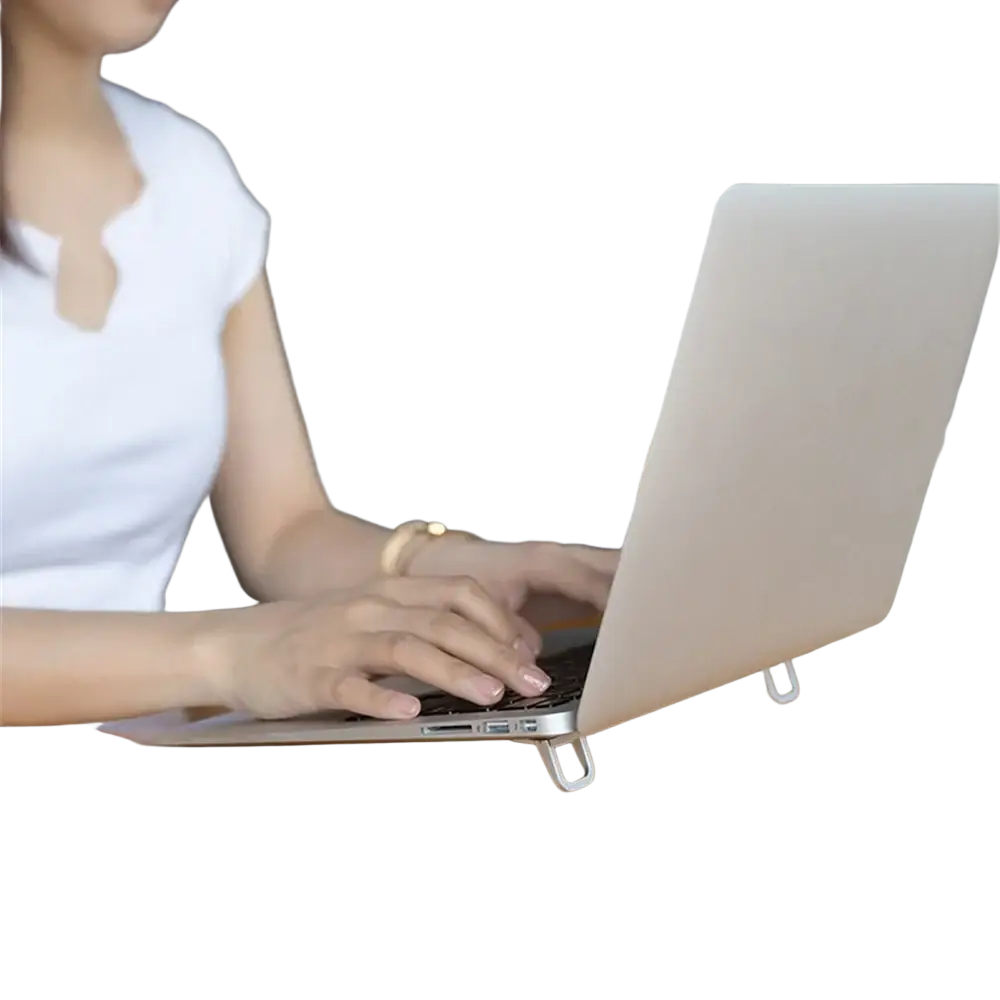 Silver aluminum portable laptop stand with portable legs supporting a beige laptop on a wooden table