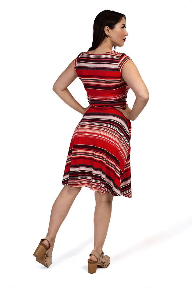 A woman wears an Amelia Retro sleeveless red and black striped fit and flare dress with a flared skirt