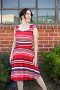 A woman wears an amelia retro striped cap sleeve fit and flare dress with bold red white and dark purple stripes