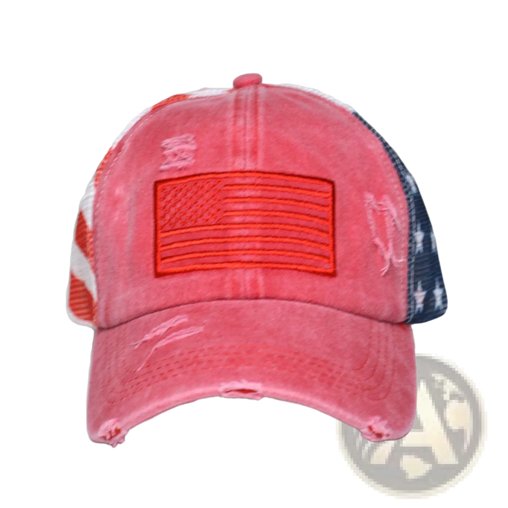 A distressed coral-colored trucker hat with orange embroidered American flag and red and blue mesh panels for women