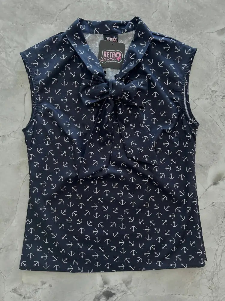 Vintage navy anchor print sleeveless bow top featuring a navy blue fabric with white anchor pattern and tied neckline bow